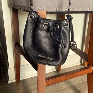 Black leather Michael Kors bucket bag. Silver hardware, crossbody length strap.